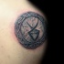 Small Celtic style detailed tattoo of small circle shaped tablet