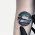 Small circle shaped arm tattoo of big island with tree