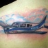 Small colored scapular tattoo of flying plane
