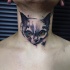 Small cute looking neck tattoo of evil face