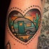 Small heart shaped little illustrative style colored tattoo on arm with trailer
