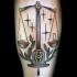 Small illustrative style tattoo of old school libra