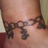 Tatuaje de cadena con animales en el tobillo