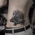 Pequeño tatuaje lateral de aspecto natural de erizo detallado