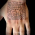Small simple black ink hand tattoo of cool labyrinth