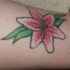 piccolo giglio bianco e rosa sulla gamba tatuaggio
