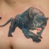 Snarling black panther  with yellow eyes tattoo