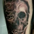 Spectacular black and gray tattoo of half human half demonic skull