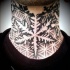 Spectacular black ink dot style neck tattoo of big snowflake