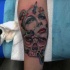 Spectacular looking colored abstract style forearm tattoo of woman mask and skull