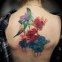 Tatuaje en la espalda, amapolas delicadas con pájaro multicolor