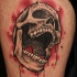spaventoso teschio nero in sfondo rosso tatuaggio