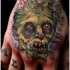 Tatuaje en la mano, zombi espantoso verde