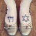 Tatuaje en los pies, 
estrella de David y símbolo hebreo, tinta negra