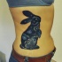 Tatuaje en las costillas, conejo pintado en cielo nocturno