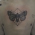 Stippling style black chest tattoo of big butterfly with small heart