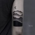 Stippling style black ink arm tattoo of mountains with moon