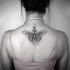 Stippling style black ink back tattoo of butterfly with ornaments