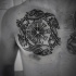 Stippling style black ink chest tattoo of tribal ornaments