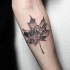 Stippling style black ink maple leaf shaped forearm tattoo stylized with mountain forest