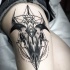 Stippling style black ink thigh tattoo of creepy skull
