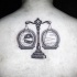 Stippling style black ink upper back tattoo of libra with moon and sun