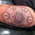 Stippling style medium size black ink arm tattoo of beautiful ornament