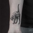 Stone like black ink wrist tattoo of typical cat