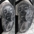 Stonework style black ink shoulder tattoo of large Buddha statue