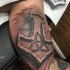 Stonework style colored biceps tattoo of ancient Celtic statue