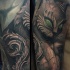 Stonework style detailed looking shoulder tattoo of cat statue with green eyes