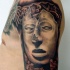 Stonework style shoulder tattoo of cool looking mask