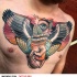 Strange looking colored chest tattoo of hand with globe and wings stylized with lettering