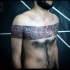 Stunning black ink detailed human finger print tattoo on chest and shoulders