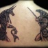 Stunning black ink detailed looking back tattoo of various Egypt Gods statues