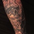 Stunning black ink forearm tattoo of human eye with clock