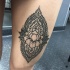 Stunning black ink thigh tattoo of Hinduism style ornament