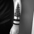 Impresionante tatuaje de brazo con tinta negra de gran árbol