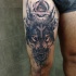 Impresionante tatuaje místico del muslo del demonio lobo con triángulo