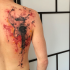 Gitarre Fragmente Tattoo am Rücken mit farbigen Farbentropfen im Aquarell Stil