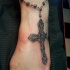 Tatuaje en el tobillo, collar con la cruz realista