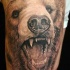 Tatuaggio spaventoso sul braccio l'orso con la bocca spalancata