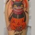 Tatuaje en la pierna, gato negro sonriente con calabaza y numero 13