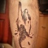 Surrealism style black ink leg tattoo of human hand with fish skeleton