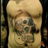 Surrealism style colored belly tattoo of human skulls with symbols