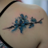 Sweet watercolor style back tattoo of tree branch with flowers