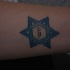 tatuaje de texto hebreo en estrella azul de david