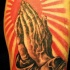 Tatuaje en color manos rezando con sol rojo al fondo