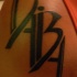 Disegno calligrafico tatuato sul deltoide