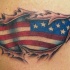 Tatuaggio con badiera americana sotto pelle stracciata